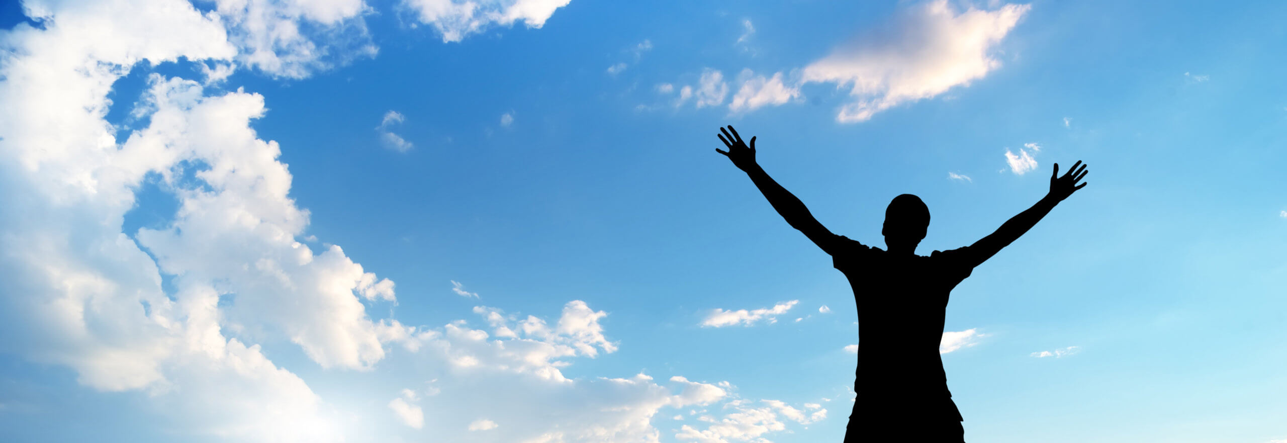 Worship. Silhouette of a man with arms stretched out to the sky